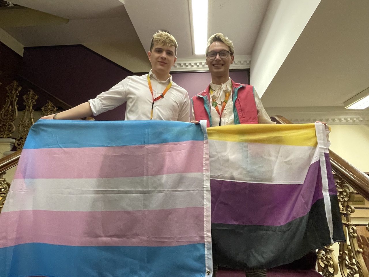 Nate Higgins (left) holding a trans flag, Danny Keeling (right) holding a non-binary flag prior to the council meeting